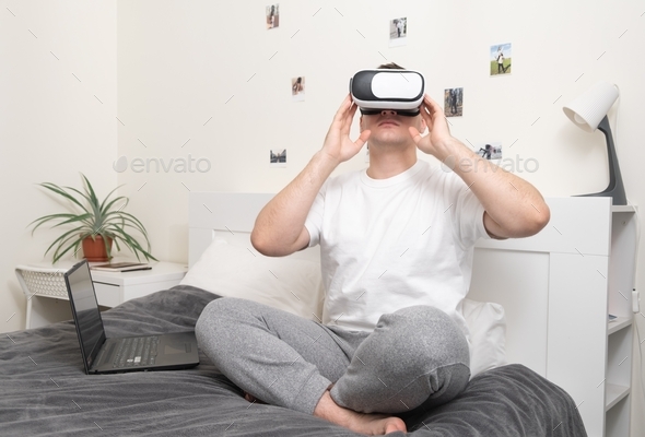 Man works at home with vr glasses and laptop. Virtual reality ...