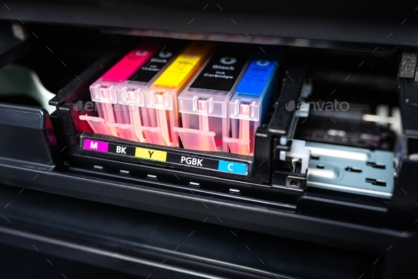 Close-up shot of a CMYK ink cartridges in a color printer.