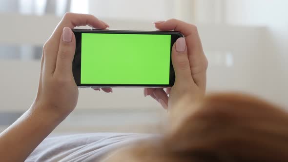 Woman in bedroom holds greenscreen display tablet computer 4K 2160p 30fps UltraHD footage - Green sc