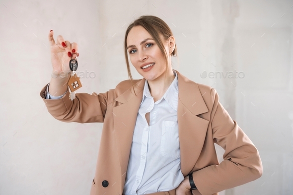 Woman hold keys with house keychain. Real estate agent sold new flat.