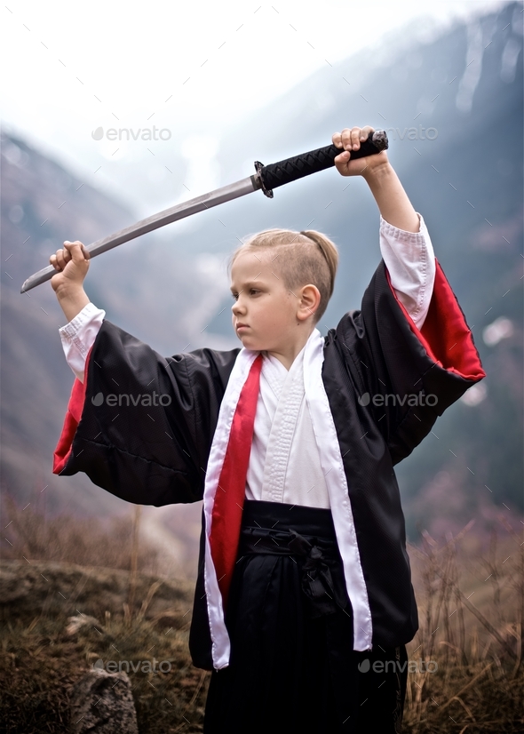 Way of the Samurai Boy dressed as a samurai stands with katana Stock