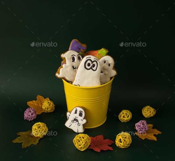 A bucket filled with gingerbreads in the form of ghosts and pumpkins. Sweet gifts for Halloween