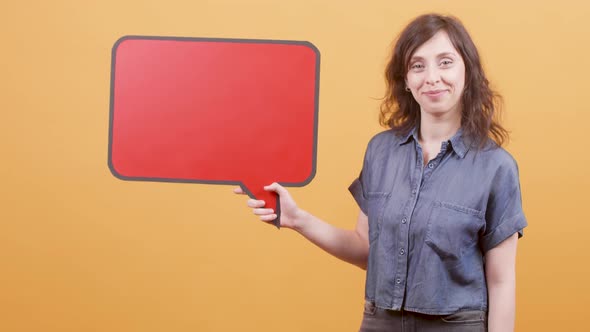Young Girl Points Her Finger To a Speech Sign for Text Insert and Approves the Message alt