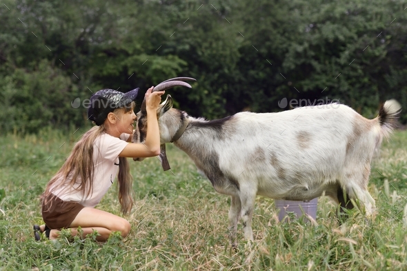 Girl holding a goat by the horns