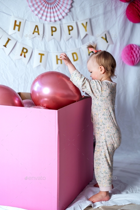 a-little-girl-on-her-birthday-takes-out-balloons-from-a-big-box-stock