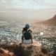 Young woman relaxing on rock above city view - PhotoDune Item for Sale