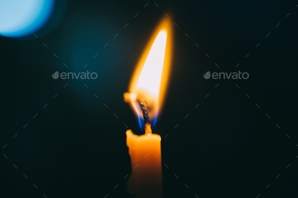 Candle light with fire in the dark as a hope in sorrow  - Stock Photo - Images