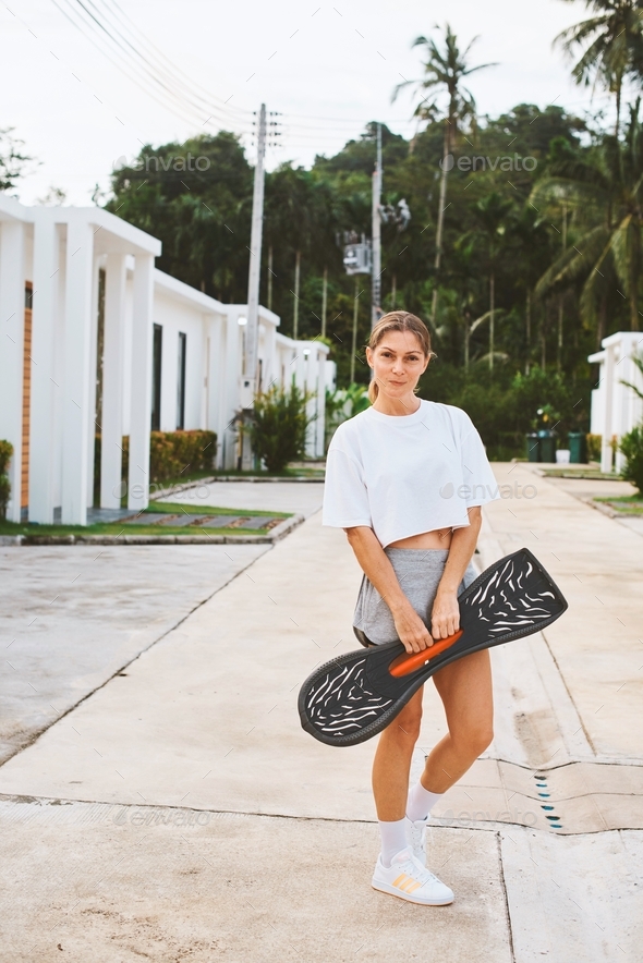 Athlete woman is skating on waveboard and have fun in golden hour