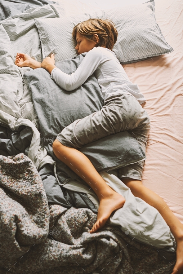 Cute 10 years old boy in sleeping time. Top view Stock Photo by olgapink