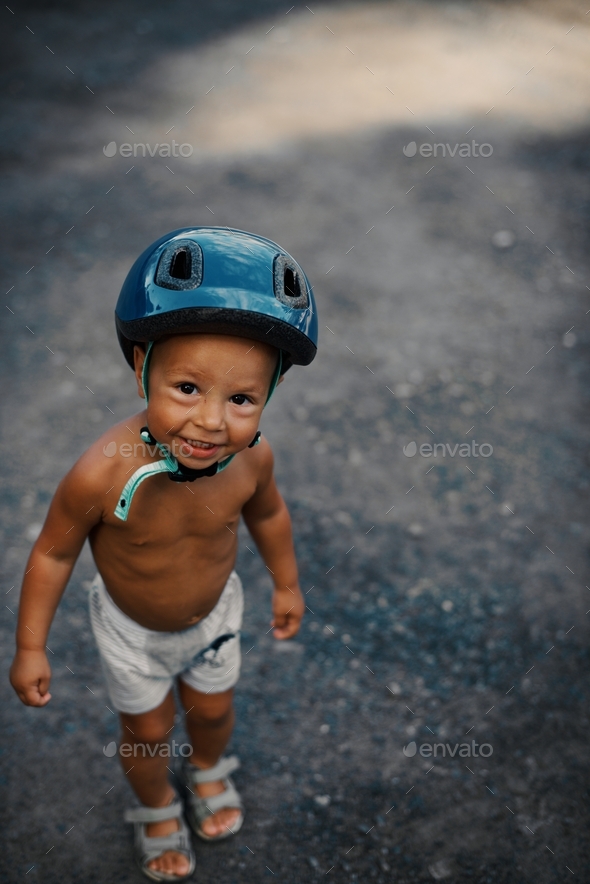 Happy kid. Little boy dressed in blue helmet looking into the camera. Carefree childhood and gratuit