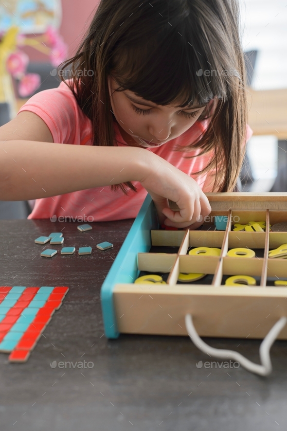 Child learning to count with a Montessori game Stock Photo by stetphotos