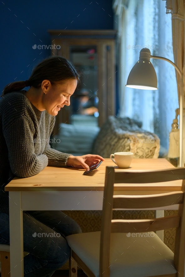 Woman using her phone at living room - Stock Photo - Images