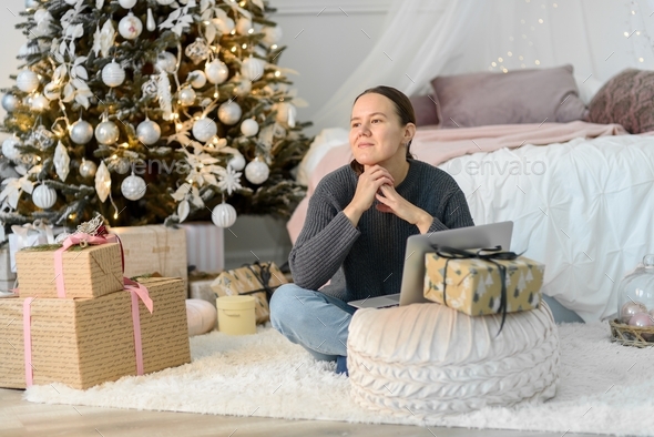 Woman with laptop, Christmas gifts and decorations - Stock Photo - Images
