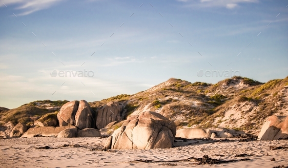 Beach rocks and dunes on a beach at sunset in Jacobsbaai, South Africa. - Stock Photo - Images