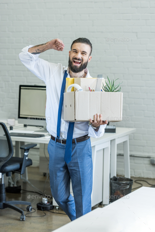 excited businessman with cardboard box in hand quitting job