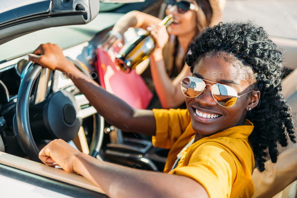 selective focus of young stylish african american woman riding car with friend