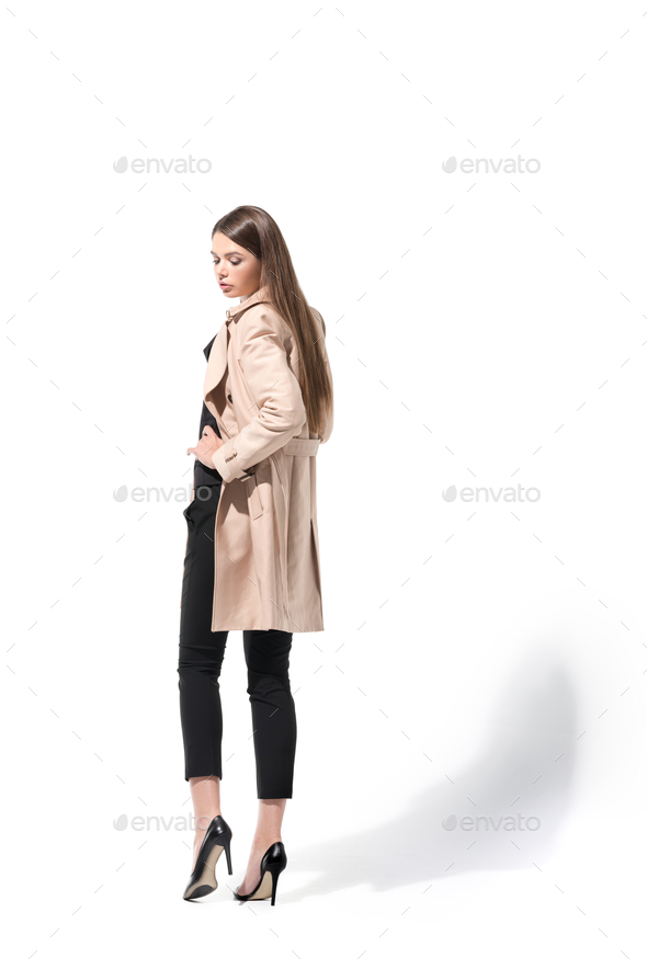Premium Photo | Full length view of trendy man with trench coat over  shoulder posing on grey with hand in pocket