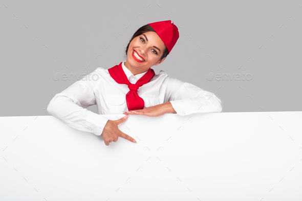 Cheerful flight attendant pointing at banner