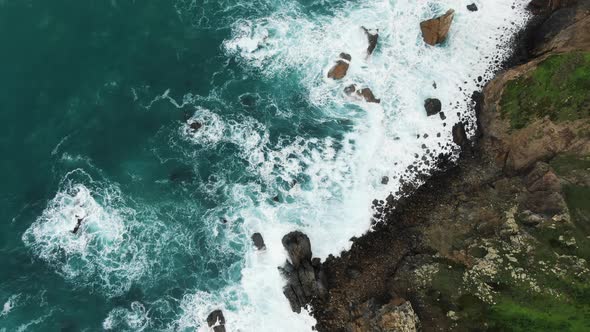 Aerial Top View Camera Lifts Up the Rocky Coast of the Cote d'Azur of the Atlantic Ocean in Cabo Da alt