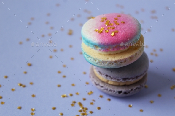 Unicorn and purple macaroons with edible gold stars. Copy space.
