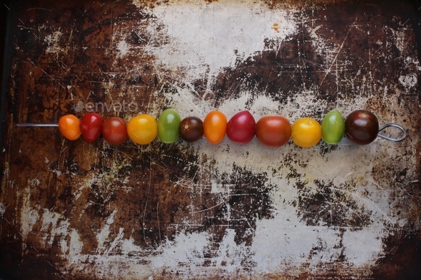 Rainbow tomatoes on baking sheet on skewer