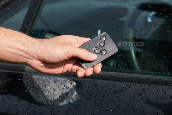Contactless ignition key for auto car in male hand, closeup view