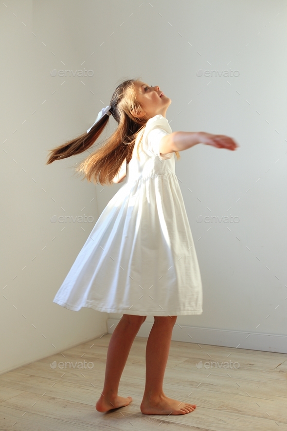The girl is spinning. child playing at home Stock Photo by nadzeyakolabava