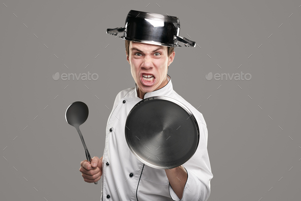 Crazy chef holding kitchenware as armor