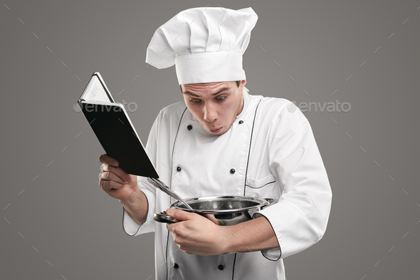 Astonished apprentice trying to cook dish