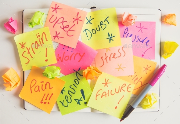 A personal or business diary covered in signs of pressure stress worry and anxiety in sticky notes