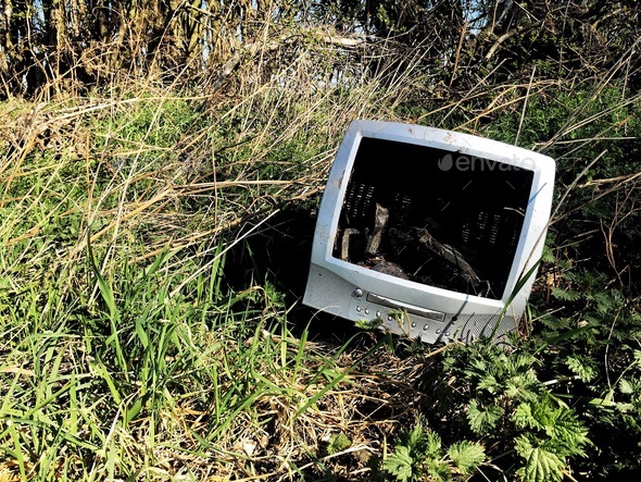 And old and out of date computer monitor dumped in wasteland in a fly tipping waste concept