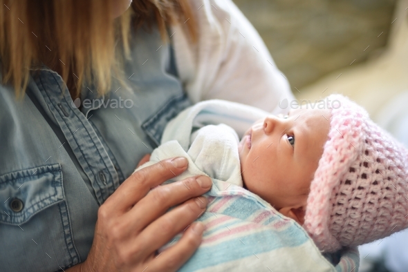 Newborn baby girl looking up at her grandma for the first time