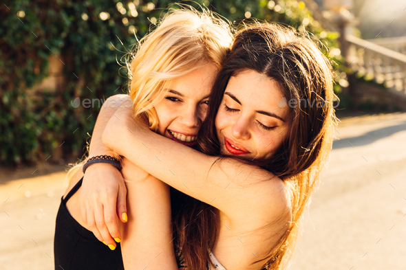 Couple of female friends hanging out together outdoors Stock Photo by ...