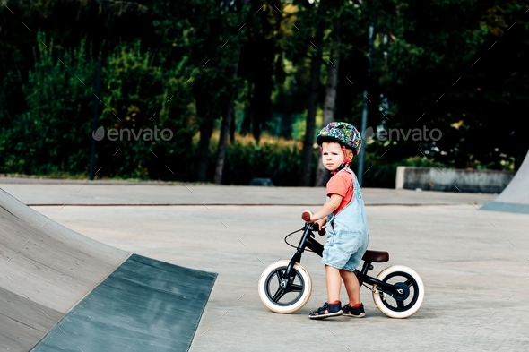 little boy in helmet holding a balance bike on the ramp Stock Photo by ...