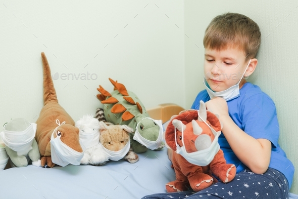 child plays role-playing games. Baby bay and his toys wearing medical mask