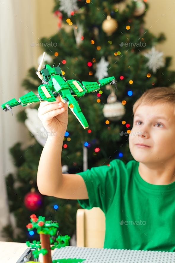 Boy playing with his pterodactyl toy made from Lego blocks Stock Photo by OlgaKhorkova