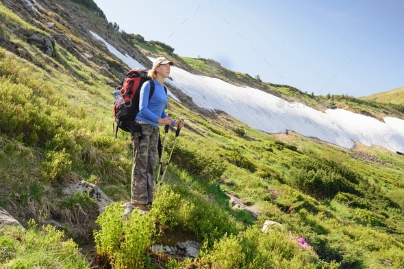 Nordic walk in mountain. Woman traveler