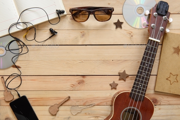 Wooden table of music composer, guitar, notebook, player, discs, headphones with free copy space. fl