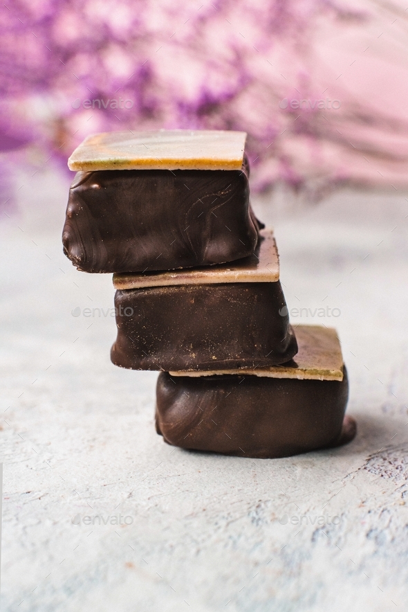 Pyramid of three chocolates on a gray background with flowers Stock