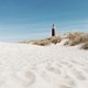 Texel island red lighthouse next to a white sand beach on a bright sunny day - PhotoDune Item for Sale
