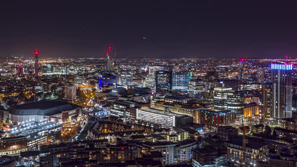 Aerial night time hyperlapse of Birmingham city centre with aircraft in the distance alt
