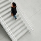 mature woman in fashionable clothes climbs the white stairs - PhotoDune Item for Sale