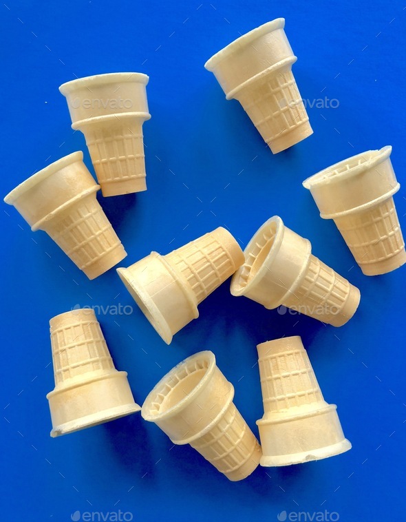 Flat lay of ice cream cones on a blue background suitable for