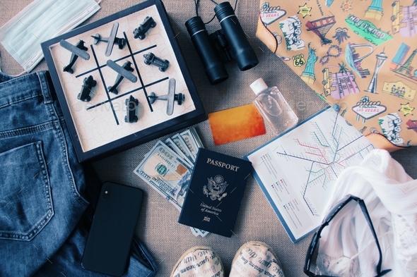 Travel essentials flat lay with a tic tac toe game with airplane & car pieces where the planes won