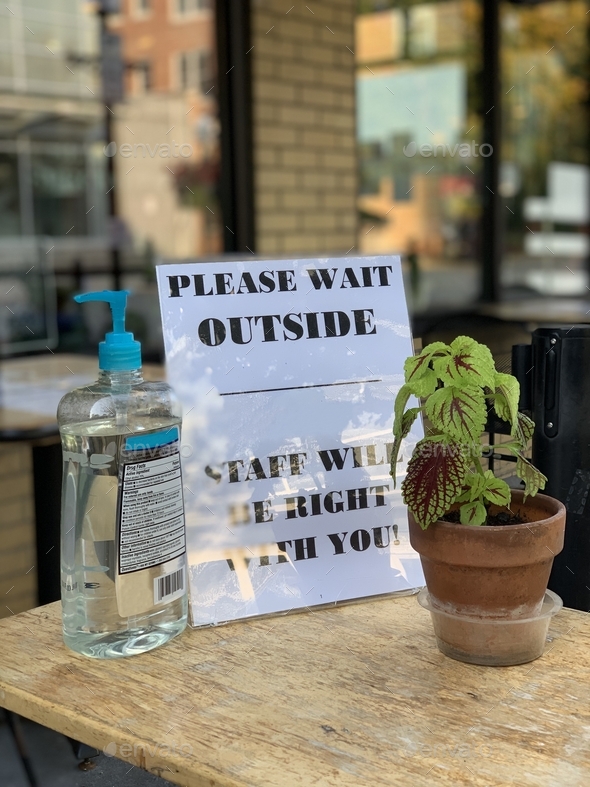Please wait outside sign with hand sanitizer at restaurant’s entrance for outdoor seating. Covid19