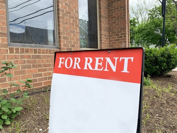 For rent sign with blank space for text overlay in front of property available for rent by realtor