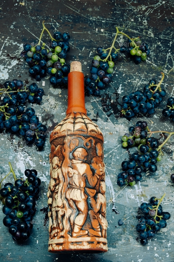 top view vintage wine bottle and dark grape on a grunge textured background