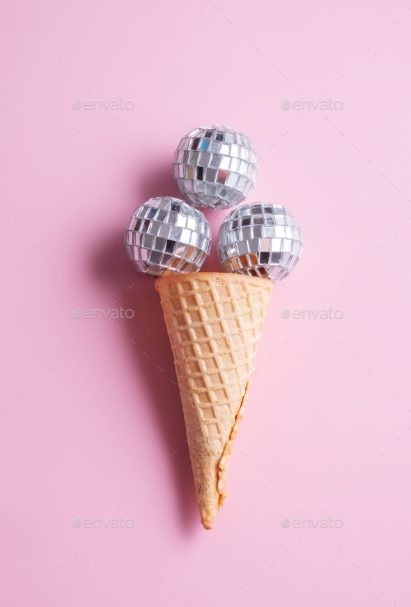 Disco ball ice cream in waffle cone on pink background. Minimal holiday party concept.