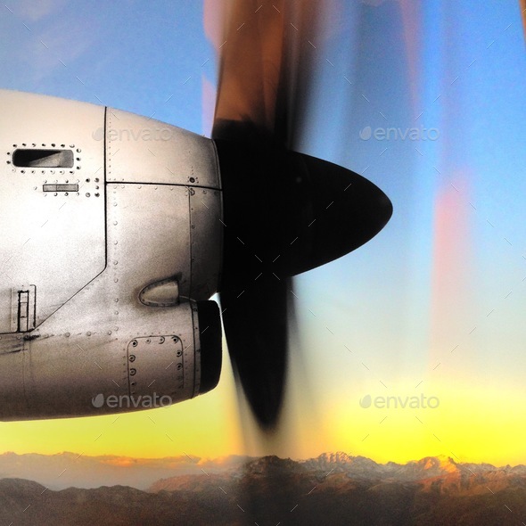 Side view of a plane propeller during a flight with sky and mountains background at sunrise  - Stock Photo - Images