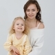 Portrait of a young pretty woman with a blond daughter in yellow dress in the studio. - PhotoDune Item for Sale